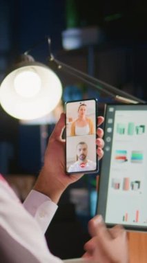 Ev müslüman yöneticisinden dikey video çalışması ve video arama verilerini kontrol eden çalışanlar. Arap yönetici anahtar performans göstergelerini optimize ediyor, telekonferans toplantısındaki ilerlemeyi tartışıyor