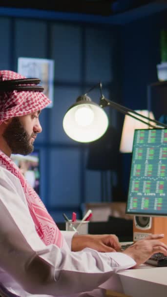 纵向视频穆斯林经纪人投资者在个人写字台核对股票交易所估值的财务盈利数字 阿拉伯电信股东商人看待市场份额增长 — 图库视频影像