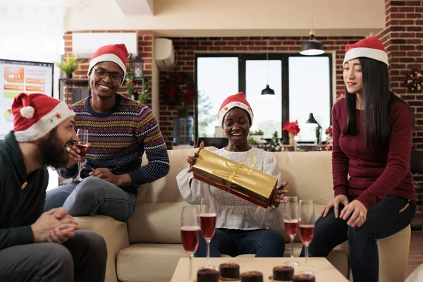 Szczęśliwa Afroamerykanka Trzymająca Świąteczne Pudełko Prezentów Kolegów Siedzących Kanapie Biurze — Zdjęcie stockowe