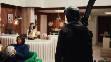 Gezgin, kadınlara dağlık yamaçlarda kayak yapmak için yol tarifi soruyor. Dağ tatil köyüne varıyor. Kış sporu için donanımlı genç adamı selamlıyor. Müşteri kayak ve koruyucu ekipman taşıyor..