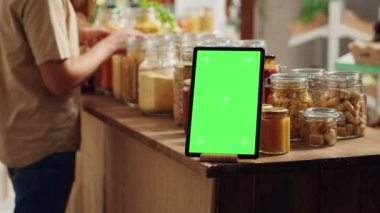 Sıfır atık süpermarketinde ticari işaret olarak kullanılan boş kopya alanı olan bir tablet, kapat. Gıda mağazasında ayrıştırılmış ekran aygıtı biyolojik olarak ayrıştırılabilir paketlenmiş ürünlerle promosyon mesajı olarak hareket ediyor
