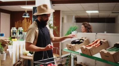 Depo görevlisi, taze hasat edilmiş çiftlik gıdalarıyla yeşil canlı biyoloji süpermarketine geliyor. Tedarikçi mahallenin bakkal dükkanını ilaçlarla dolduruyor. Etik olarak ücretsiz sebzeler.