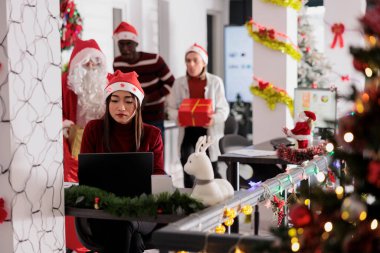 Şenlikli ofisteki iş arkadaşları yorgun çalışanları şaşırtmak için takım oluşturup işlerini bitirmeye odaklandılar. Noel Baba gibi davranan işçiler, tatil sezonunda hediyelerle iş arkadaşının arkasına sızıyorlar.