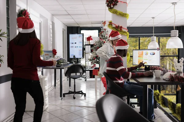 クリスマスシーズン中に お祝いの装飾オフィスでグラフを扱う多様なビジネスチーム Xmas休日の周りの会計図をチェックする勤勉な従業員 — ストック写真
