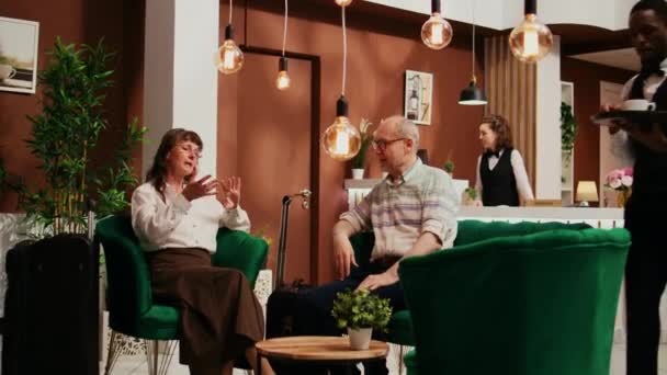 Bellhop Ofrece Una Taza Café Los Huéspedes Que Esperan Sala — Vídeos de Stock