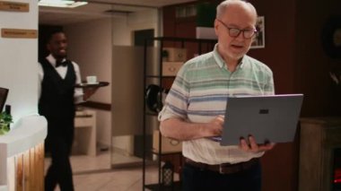 Prosedürü kaydetmeden önce oteldeki kablosuz bağlantıyı kullanarak laptopta ziyaret etmek için yer arayan yaşlı kişi. Emekli adam tatilde yurt dışına seyahat ediyor, internetten bilgi topluyor.