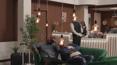 Uluslararası uçuştan sonra otel lobisinde uyuyan insanlar jet-lag ve yorgunluktan muzdaripler. Uykucu gezginler oda kontrolünden önce dinlenme odasında uzanıyorlar..