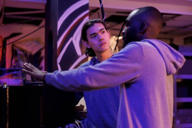 Bilgisayar korsanları yasadışı faaliyetler planlarken kötü amaçlı yazılım kodlarını tartışıyorlar. Afro-Amerikan ve Asyalı suçlular terk edilmiş depoda online sunucu hackleme tekniği hakkında konuşuyorlar.