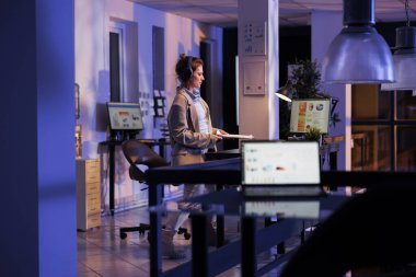 Olumlu iş kadını müzik dinliyor ve açılış ofisinde eğleniyor. Gece geç saatlere kadar şirket açılışında çalışıyor. Dinlenme zamanının tadını çıkaran kulaklıklı neşeli yönetici. Şirket kavramı