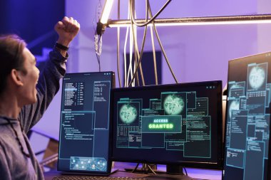 Bilgisayar sistemine erişimi ve yasadışı faaliyetleri kutlayan bir bilgisayar korsanı. Terk edilmiş depoda veri tabanını başarıyla hackledikten sonra zafer jesti için elini kaldıran genç Asyalı adam.