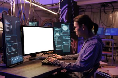 Asyalı hacker, suç işlemek için boş beyaz ekranlı bilgisayar kullanıyor. Yasadışı kötü niyetli yazılım programlama ve geceleri boş monitördeki kodu kontrol etme