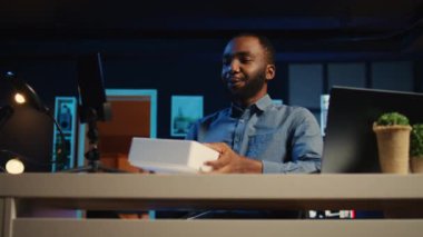 Teknik içerik yaratıcısı RGB 'de paketlenmiş ürünleri boks yaparken kaydediyor. Kişisel ev stüdyosunu aydınlatıyor. Destekleyici, abonelere sponsorluk yapan ürünleri gösteriyor, kalça seviyesinde çekim.