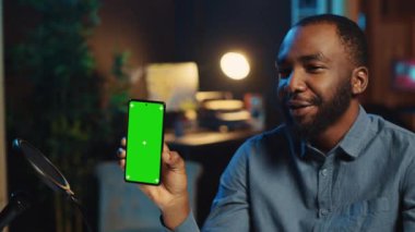 Gülümseyen BIPOC içerik yaratıcısı teknoloji meraklıları için akıllı telefon video eleştirisi hazırlıyor. Moda yıldızı teknoloji internet şovuna ev sahipliği yaptı, izole ekran cep telefonunu açtı