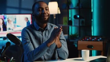 Afrikalı Amerikalı içerik yaratıcısı profesyonel kayıt ekipmanlarını kullanarak çevrimiçi yayın platformları için kanal girişini filme alıyor, kapatın. Viral çevrimiçi yıldız hayran kitlesini selamlıyor, bugün video konusunu sunuyor