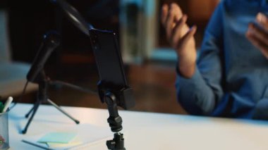 Çevrimiçi yayın platformları için video çekmek için internet yıldızları tarafından loş ışıklandırılmış ev stüdyosunda kullanılan akıllı telefonun yakın çekim görüntüsü. Nüfuzlu biri tarafından çekimleri kaydetmek için cep telefonu kullanılıyor.