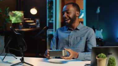 Afrikalı Amerikalı internet yıldızı çevrimiçi platform kanalı için Bluetooth taşınabilir hoparlörünün teknoloji değerlendirmesini yapıyor. BIPOC etkileyicisi müzik çalma aygıtını izleyicilerine sunar