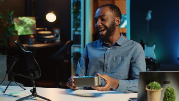 非裔美国人网络明星为在线平台频道做蓝牙便携式扬声器的技术回顾 Bipoc影响者向观众展示音乐播放设备 — 图库视频影像
