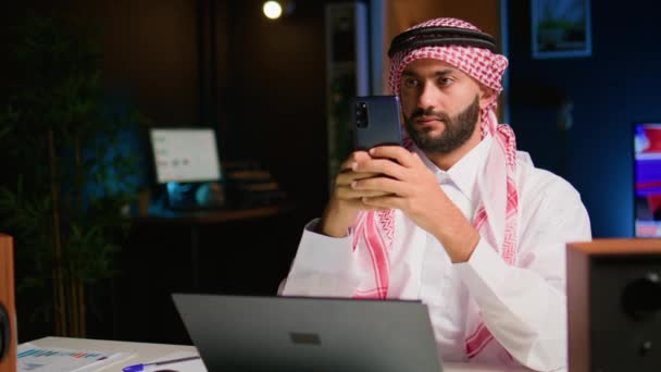 Porträtt Glad Arabisk Distansarbetare Skicka Sms Till Vänner Samtidigt Som — Stockvideo