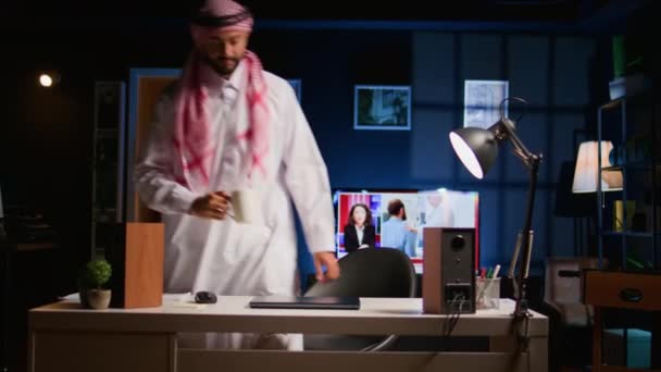 アラブの従業員がスタイリッシュなアパートの個人オフィスに到着し 重要な仕事を開始します ラップトップのキーボードにタイピングする集中イスラム教徒のテレワーカー 自宅で作業シフトを開始 — ストック動画
