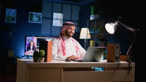 アラビア語の求職候補者は 自宅にいる間に人事チームから遠隔でインタビューを受けています 笑顔のイスラム教徒の男性は 雇用される前に オンラインビデオ会議で彼の資格情報をチェックする — ストック動画