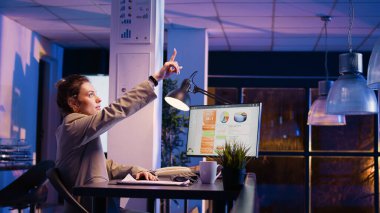 Şirket çalışanı, holografik görüntü 3D peyzaj kullanarak metaevren hologramını analiz ediyor ve diyagramlarla finansal yatırım planlıyor. Ekonomiyi kontrol eden kadın danışman analitik grafikler çiziyor.