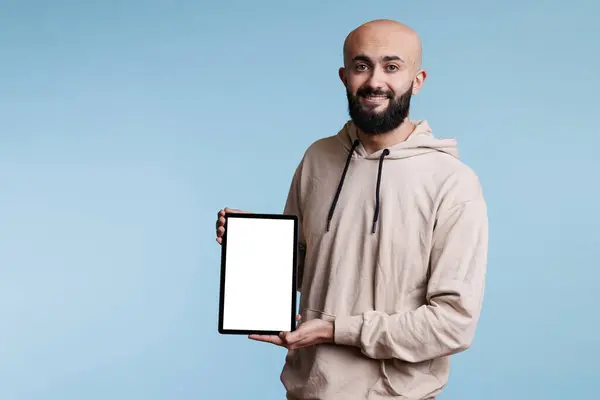 デジタルタブレットの白い空白のスクリーンの肖像画の広告を提示する笑顔のアラブの男 ポータブルガジェットを保持し ソフトウェアアプリケーションプロモーションのためにモックアップを表示する陽気な人 — ストック写真