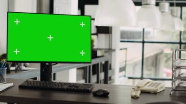 İş ajansı ofisinde yeşil ekran monitörlü çalışma masası, şirket operasyonlarında kullanılan modern cihazlarla birlikte çalışma alanı boş. Ekranda krom anahtar ve model şablonu gösteriliyor.