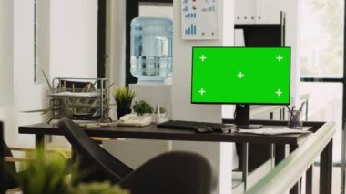 Bilgisayarda yeşil ekran çalışan boş çalışma istasyonu, krom anahtar şablonu ile izole ekran sunan açık kat ortak çalışma alanı. Boş telif alanı düzenini gösteren masadaki monitör.