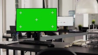 Bilgisayarlı boş masa monitörde yeşil ekran gösteriyor. İş ofisindeki boş kopya alanı çalıştırıyor. PC ve izole edilmiş kromakey şablonu ile açık kat planlama ofisinde çalışma istasyonu.