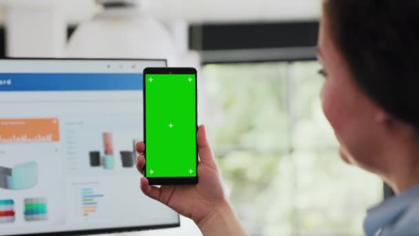 工作人员检查智能手机上的绿色显示屏 在协同工作空间中保存带有空白软件的设备 在代理办公室与孤立的模拟展示一起工作的妇女 靠近点 — 图库视频影像