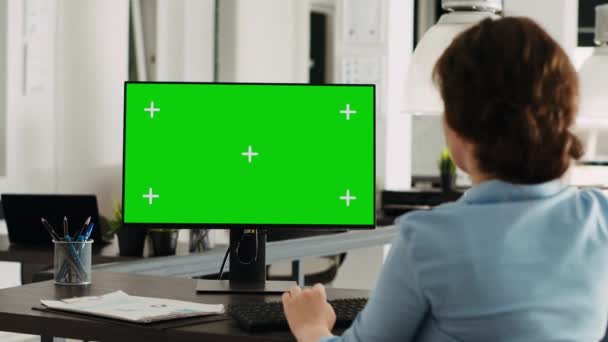 Pcモニターで緑色のディスプレイを使用する労働者は コワーキングスペースで隔離されたモックアップテンプレートを見ています クリエイティブエージェンシーの従業員がコンピュータ スタートアップ企業の空白の染色体スクリーンをチェック — ストック動画