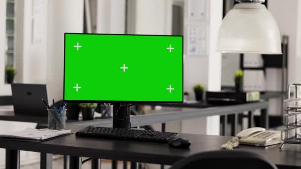 コワーキングスペースの隔離された染色体テンプレートを示すディスプレイに緑色のPcを実行している空のオフィスデスク モニターとコピースペースのレイアウトによるオープンフロアプランのワークステーション — ストック動画