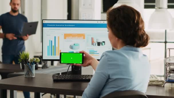 办公室职员看着智能手机显示应用程序上的绿色屏幕 分析工作中移动设备上孤立的铬键布局 拿着显示空白模型模板的电话的女人 — 图库视频影像