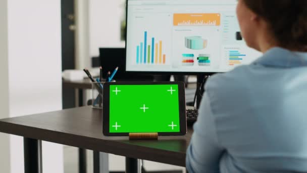 公司员工在新成立的公司办公室的办公桌上放有绿色显示屏的平板电脑 使用空白的模型模板和隔离的铬钥匙布局 在设备上观看数字网络应用的妇女 — 图库视频影像