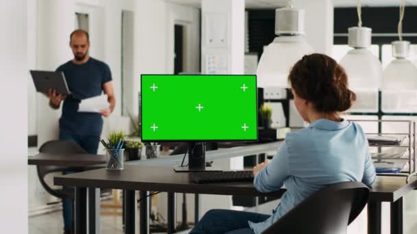 小規模ビジネスエージェンシーの職場でデスクトップモニター上のグリーンスクリーンテンプレートを見るスペシャリスト 空白の染色体のモックアップ 問題解決を示す孤立した表示をチェックする人 トリポッドショット — ストック動画