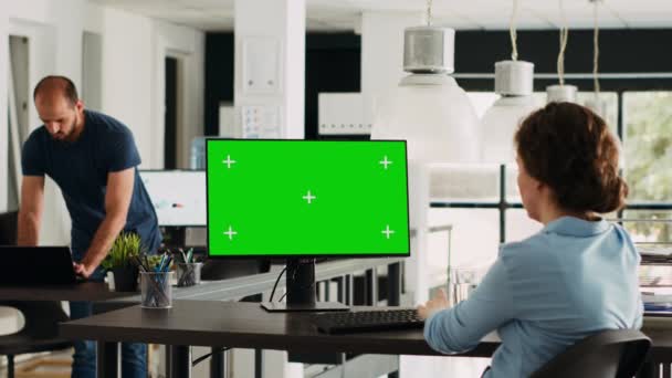 クロマケイの分離された緑色の表示に依存する企業のオペレータ スタートアップの職場でコンピュータを使用する会社幹部は モックアップテンプレートを調べながら 代理店事務所で働いています トリポッドショット — ストック動画