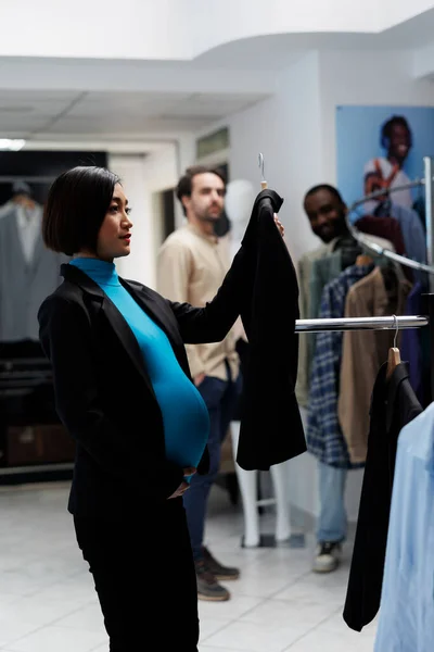 Pregnant Asian Customer Examining Clothing Rack Holding Jacket Hanger Department — Stock Photo, Image