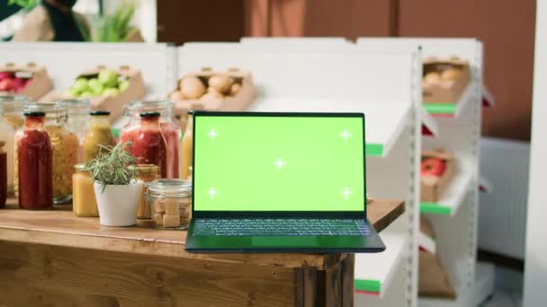 新鮮な収穫された果物と野菜 持続可能なライフスタイルのコンセプトで満たされたバイオショップで緑色を表示するラップトップ コンピュータは ゼロ廃棄物ストアで隔離された染色体テンプレートを示しています — ストック動画