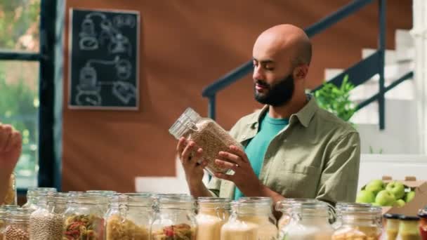 Comerciante Mostrando Condimentos Productos Alimenticios Recipientes Frascos Cliente Vegano Mientras — Vídeos de Stock