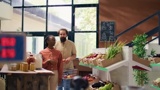 Satıcıya Organik Doğal Süpermarketteki Ürünler Hakkında Soru Soran Çift Önlüklü — Stok video