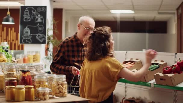 Торговец Нулевыми Отходами Супермаркете Помогает Пожилому Клиенту Покупками Добавляя Необходимые — стоковое видео