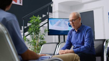 Hastane resepsiyonunda oturan yorgun ve yaşlı bir hasta sağlık muayenesi sırasında tıbbi muayeneye başlamak için uzman doktoru bekliyor. İlaç hizmeti ve destek