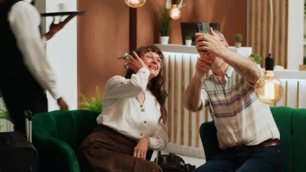 上了年纪的夫妇在酒店拍照 记录所有与国际度假有关的活动 甜蜜的夫妻在智能手机上拍照 在退休旅行中留下回忆 — 图库视频影像