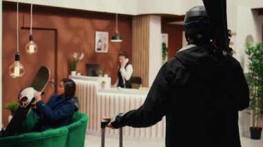 Adam personele, kış aylarında Alp Otel girişinde kayak takımları ve turizm sektöründe kayak ekipmanları bulundururken ekstrem sporları soruyor. Otel misafiri, kar yamaçlarında eğlenmeye hazır. El kamerasıyla..