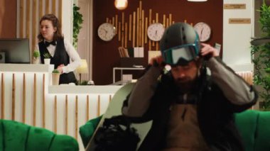 Asyalı bir insan Alp Dağı 'ndaki yamaçlarda kayak yapmaktan bahsediyor. Kış zamanı otele gelip eğleniyor. Sürgülü giysisi ve koruyucu kaskı olan kadın. El kamerasıyla..