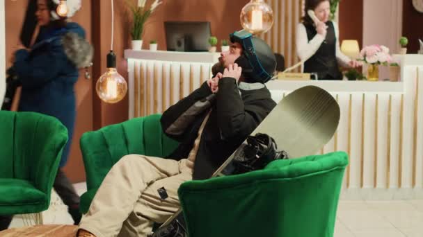 Junges Paar Mit Schiebetüren Auf Sofa Sitzend Loungebereich Mann Und — Stockvideo