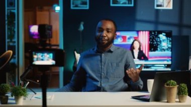 İçerik yaratıcısı alışveriş poşetleri tutuyor, video kayıt cihazlarını kullanarak loş ışıklı stüdyoda video çekiyor. İnternet yıldızı, profesyonel kamera kullanarak aldığı kıyafetlerin videosunu yapıyor.