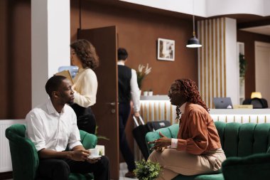 Otele yerleşmeye hazırlanan ve dinlenme odasındaki kanepede bekleyen turistler, lüks modern tatil ve geniş odalı tatil için heyecanlanıyorlar. Genç çiftin konaklama yeri.