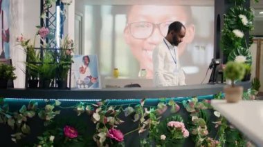 Afro-Amerikalı bir adam kasadaki ikinci el dükkanındaki eski müşterileri kontrol ediyor ve kıyafet siparişlerini alıyor. Boş ikinci el mağazasındaki kasiyer verileri karşılaştırıyor