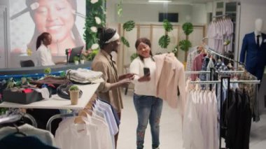 Erkek arkadaşın, kadına elbise mağazasından şık kıyafetler seçmesinde yardım ediyor. Premium moda mağazasından alınmış yeni kıyafetlerle fotoğraf çeken çift.
